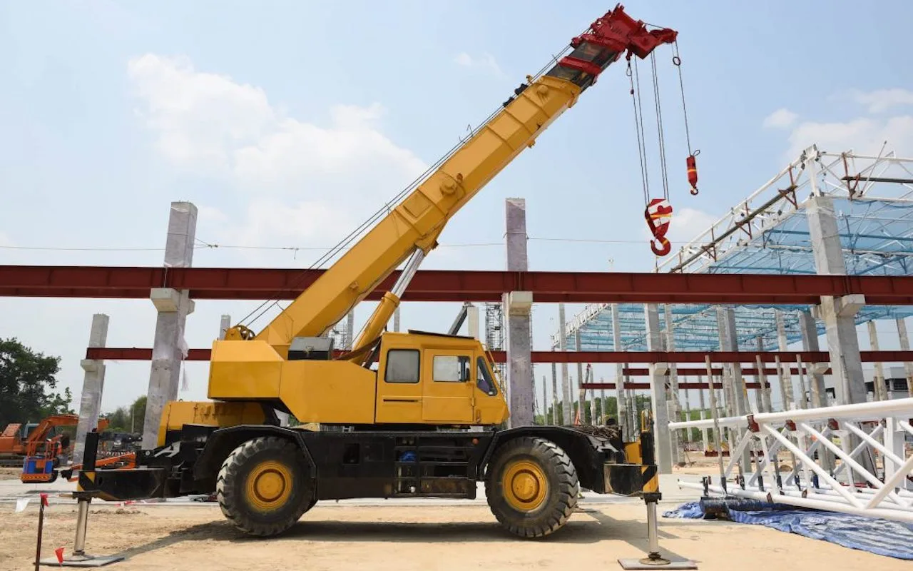 Mobile crane positioned beside a steel-frame construction project